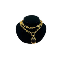 Vintage Joan Rivers gold link necklace with smoky brown topaz glass pendant displayed on black velvet bust.