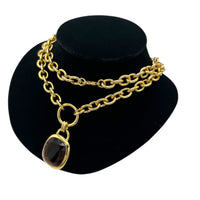 Side view of Vintage Joan Rivers gold link necklace with smoky brown topaz glass pendant displayed on black velvet bust.