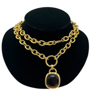 Close up vie of Vintage Joan Rivers gold link necklace with smoky brown topaz glass pendant displayed on black velvet bust.