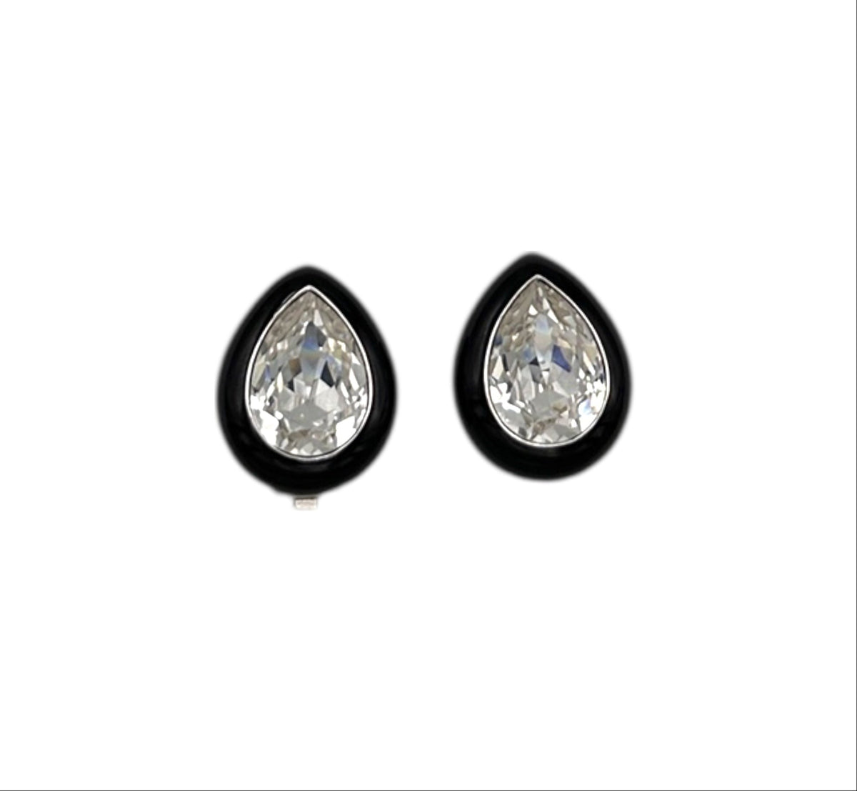 Close up view of Vintage Kenneth Jay Lane clear teardrop rhinestone clip-on earrings with black enamel border displayed on white background.