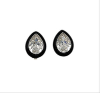Close up view of Vintage Kenneth Jay Lane clear teardrop rhinestone clip-on earrings with black enamel border displayed on white background.