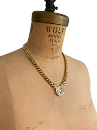 Vintage Swarovski gold-tone link necklace with large faceted crystal medallion pendant displayed on mannequin bust.