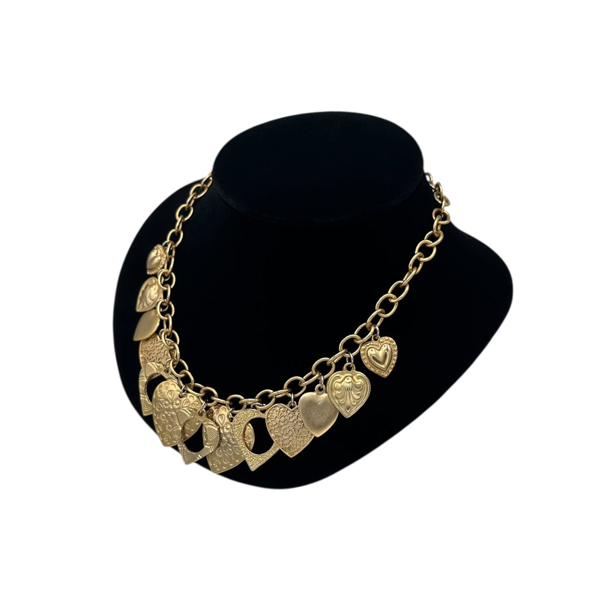 Side view of Vintage gold heart charm necklace with textured hearts and link chain displayed on black velvet bust.