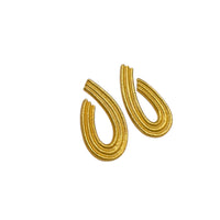 Side view of Vintage Givenchy gold teardrop dangle earrings with textured finish displayed on white background.