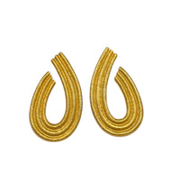 Close up view of Vintage Givenchy gold teardrop dangle earrings with textured finish displayed on white background.