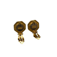 Back view with clips open of Vintage Ciner gold clip-on earrings with round blue lapis glass cabochons displayed on white background.