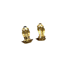 Clip view of Vintage Ciner gold clip-on earrings with round blue lapis glass cabochons displayed on white background.