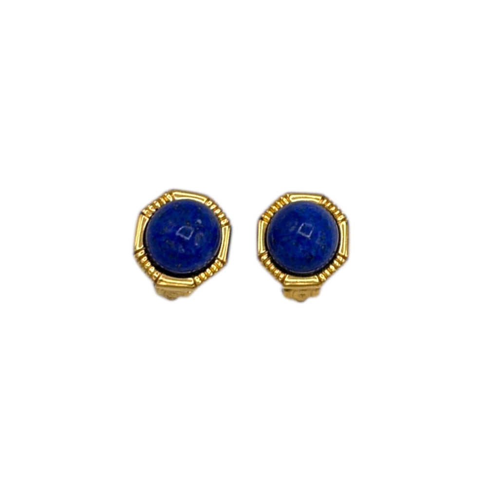 Vintage Ciner gold clip-on earrings with round blue lapis glass cabochons displayed on white background.