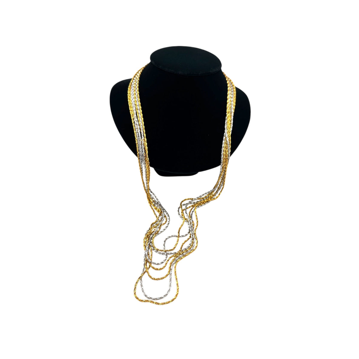 Crown Trifari signed vintage gold and silver multi-strand chain necklace on black bust and white background.