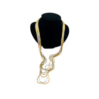Crown Trifari signed vintage gold and silver multi-strand chain necklace on black bust and white background.