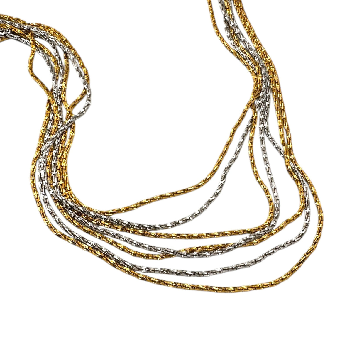 Close up view of Crown Trifari signed vintage gold and silver multi-strand chain necklace on white background.