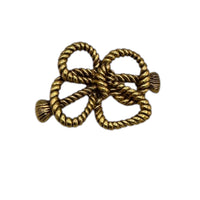 Close up view of MMA vintage gold rope bow brooch with textured loops on white background.