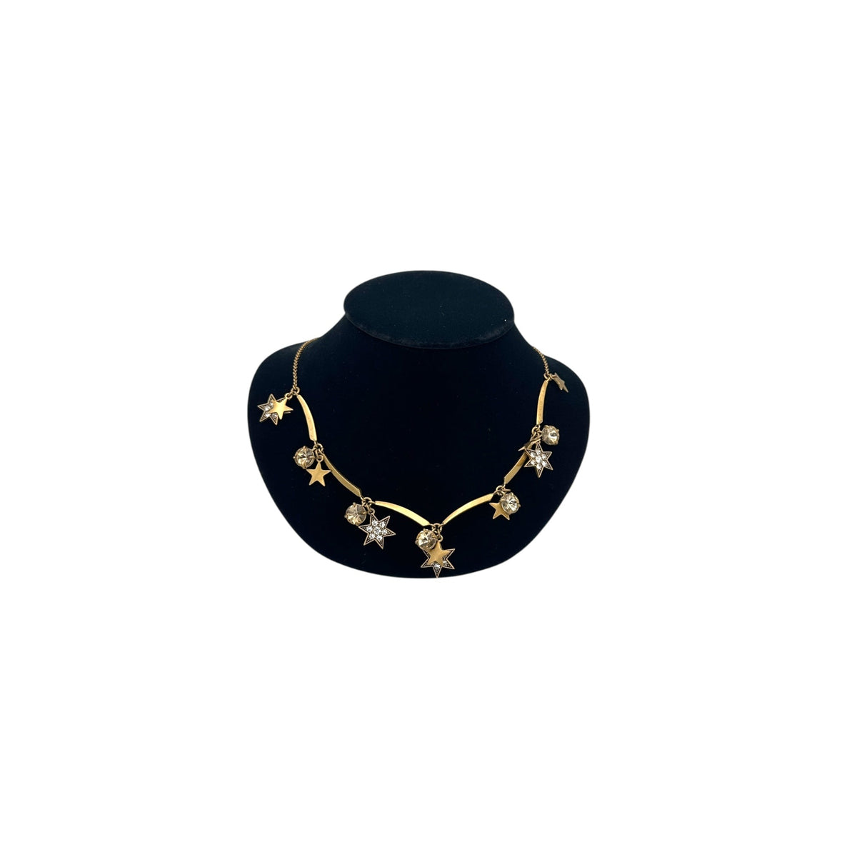 J. Crew vintage antiqued gold star charm necklace with rhinestone accents displayed on a black jewelry bust.