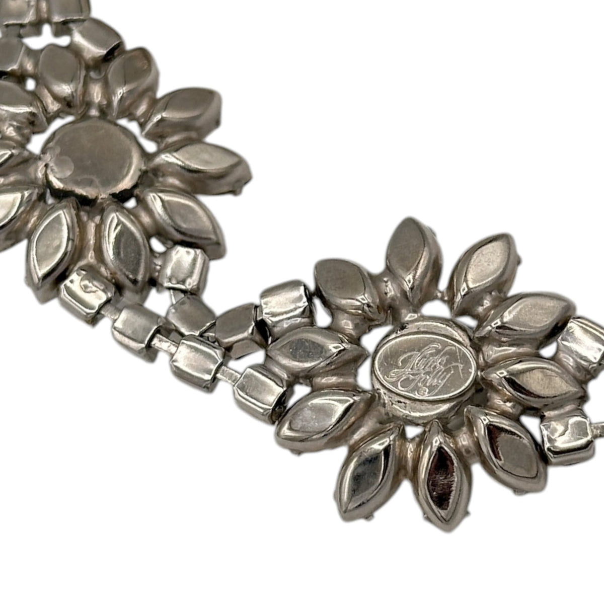 close up view of Signature of Kirks Folly vintage bracelet with clear and black rhinestone flower design on white background.