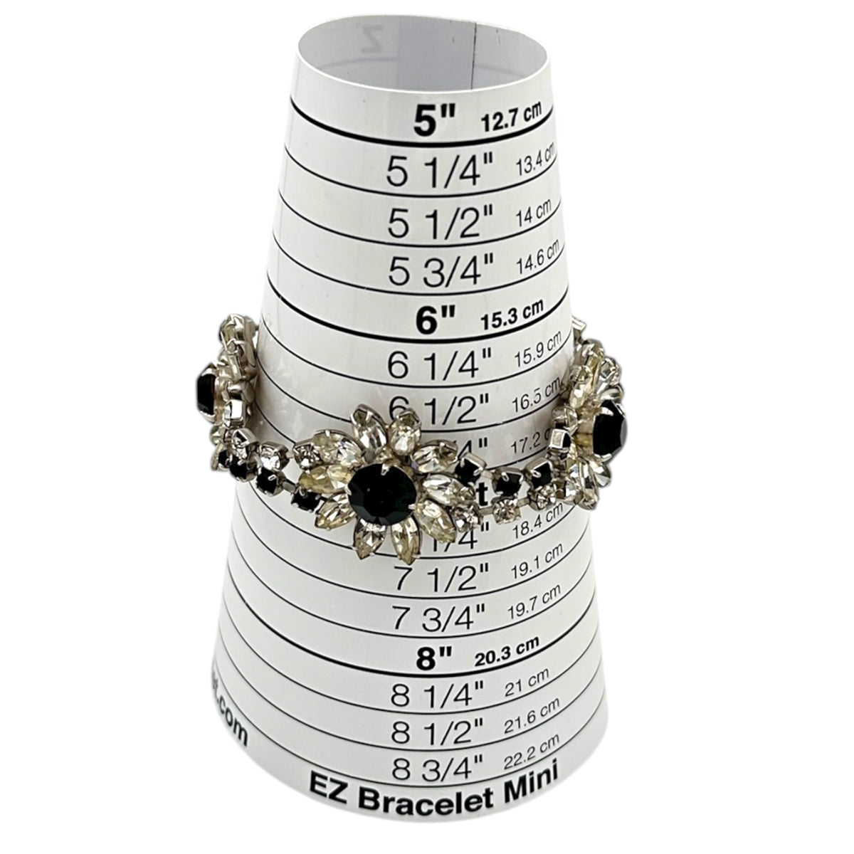 On sizer Kirks Folly vintage bracelet with clear and black rhinestone flower design on white background.