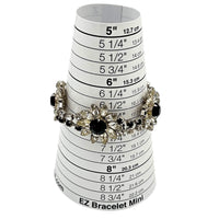 On sizer Kirks Folly vintage bracelet with clear and black rhinestone flower design on white background.