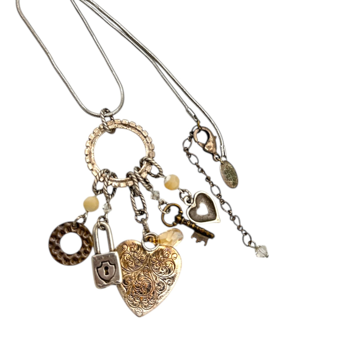 Back of pendant of Vintage Liz Palacios San Francisco silver charm necklace with heart and key pendants displayed on white background.