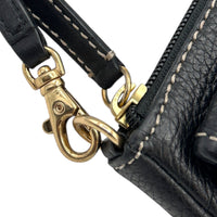 Zipper and clasp view of Vintage Michael Kors black pebbled leather Roadie bag with gold hardware and dual front pockets displayed on white background.
