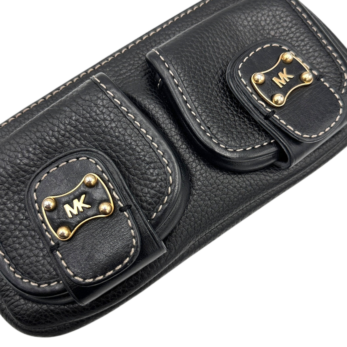 Close up of front pockets of Vintage Michael Kors black pebbled leather Roadie bag with gold hardware and dual front pockets displayed on white background.