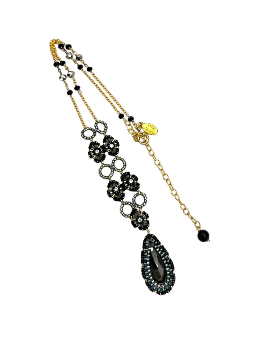 Miguel Ases gold-filled necklace with black beaded teardrop pendant and layered strand design.
