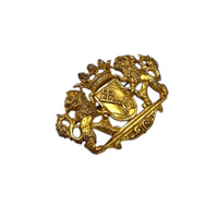 Side view of Miriam Haskell gold lion crest vintage brooch with crown and coat of arms design on white background.