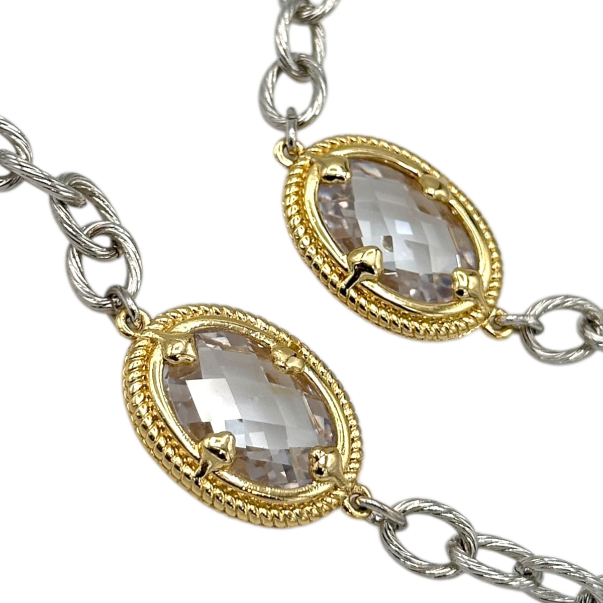 Close up of crystals and chain of Vintage mixed metal long cable chain necklace with gold bezel-set oval crystals displayed on white background.