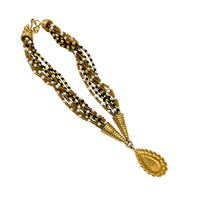 Back view of Monet vintage gold multi-strand beaded necklace with a brown teardrop pendant and gold accents on white background.