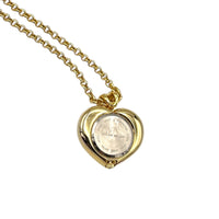 Back view of watch of Vintage Nolan Miller gold heart pendant watch with rhinestone accents on long cable chain displayed on white background.