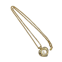 Vintage Nolan Miller gold heart pendant watch with rhinestone accents on long cable chain displayed on white background.