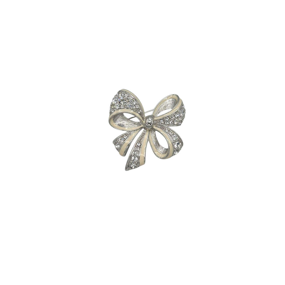 Nolan Miller vintage silver bow brooch with white enamel and clear rhinestones, photographed on white background.