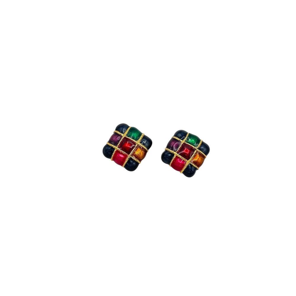 Close up view of Vintage Premier Design jewel-tone enamel clip-on earrings with gold grid design in red, green, and amber colors – 1980s statement jewelry shown on white background.