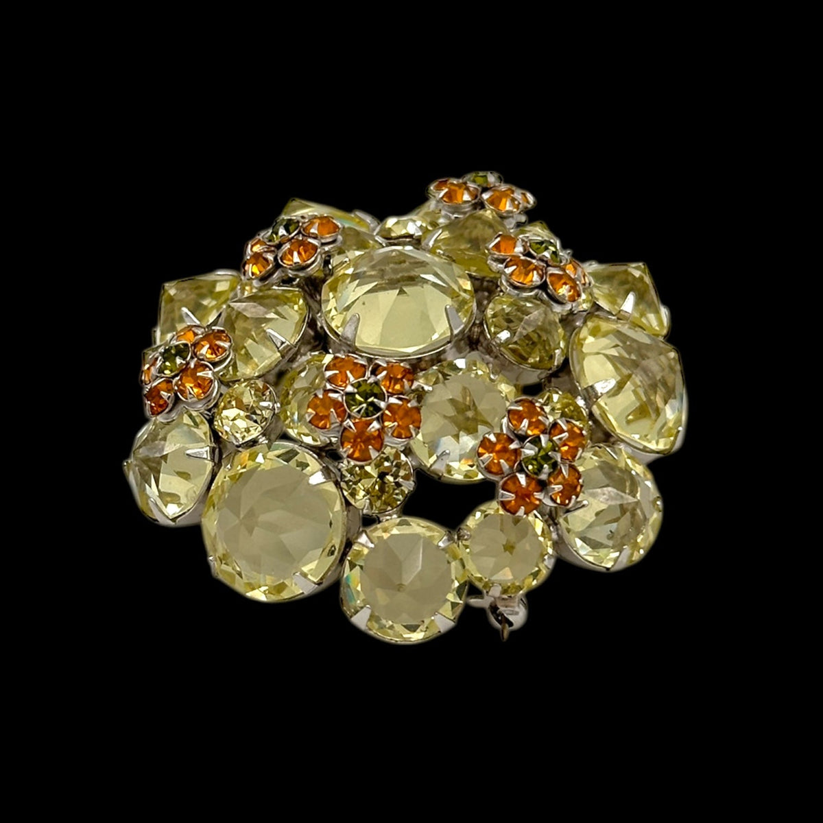 Side angle of Schreiner brooch on black background.