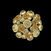 Top view of Schreiner brooch on black background.