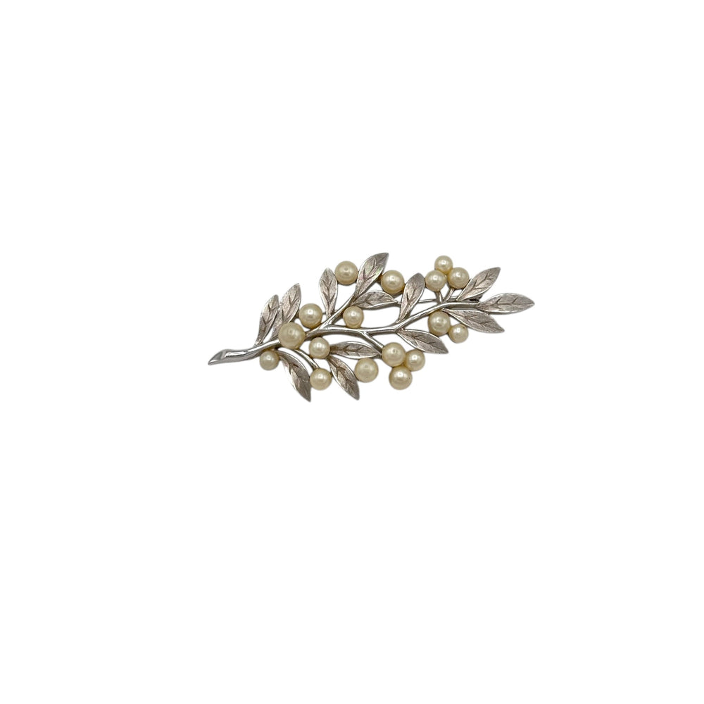 Vintage Trifari silver leaf and pearl brooch with branch design displayed on white background.