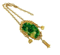 Vendome Asian-inspired vintage pendant necklace with faux carved green jade, gold-tone frame, figural charms, and dangle drop.