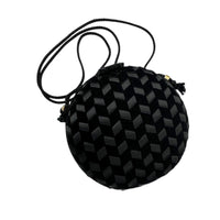 Close up view of Vintage black round velvet and satin weave small crossbody handbag with cord strap displayed on white background.