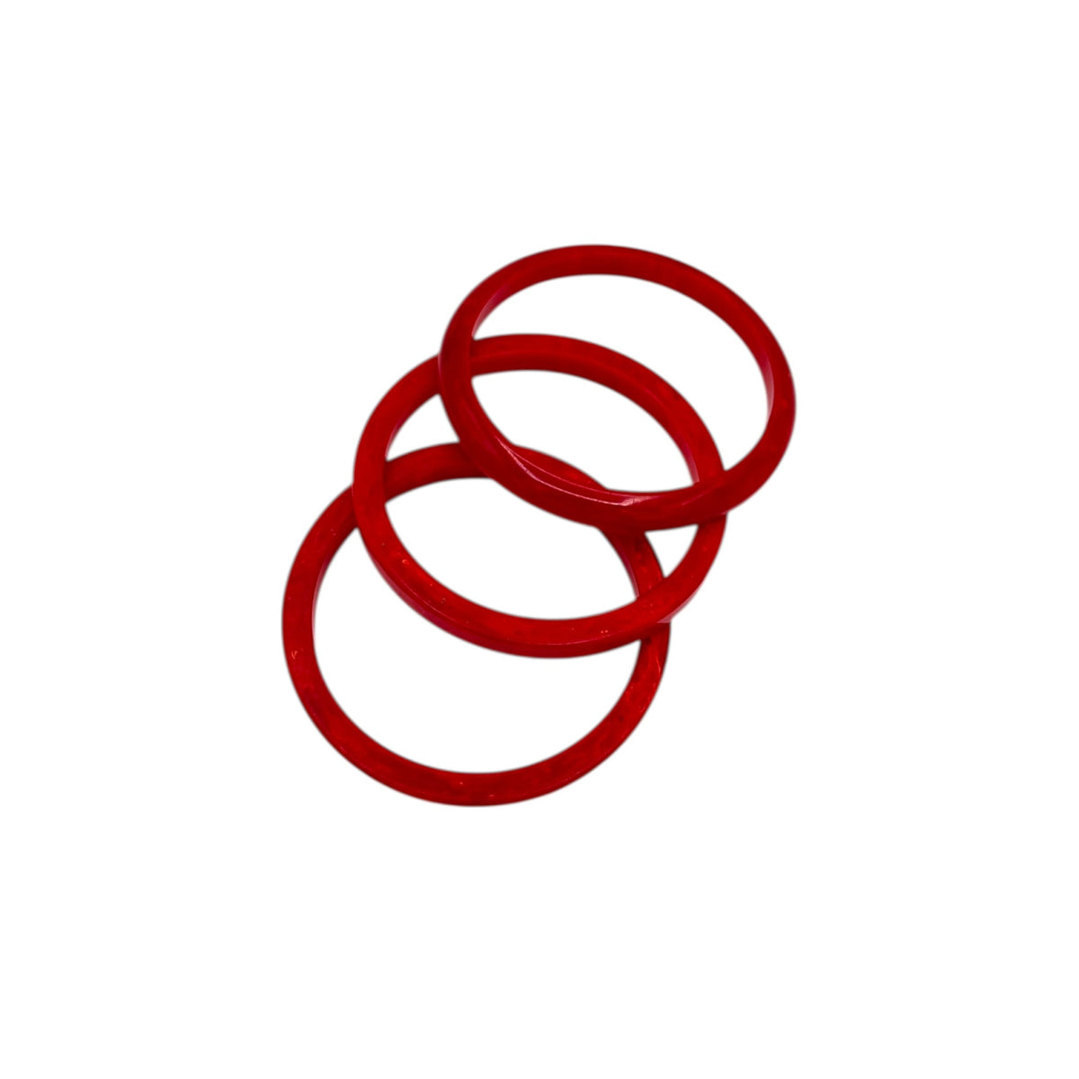 Close up view of Flat lay view on white background of Set of three vintage cherry red Bakelite bangles.