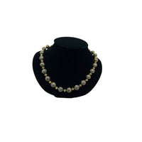 Vintage green and gold floral cloisonné bead hand-knotted necklace with scalloped enamel design displayed on black bust.