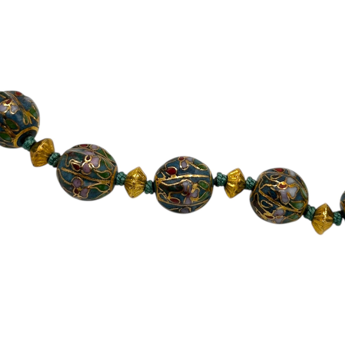 Close up of spacer beads of Vintage green and gold floral cloisonné bead hand-knotted necklace with scalloped enamel design displayed on black bust.