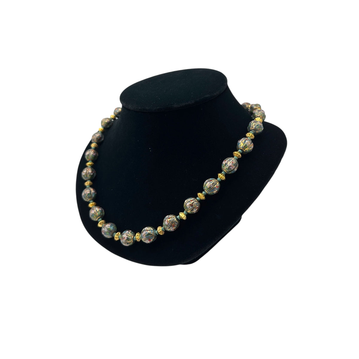 Side view of Vintage green and gold floral cloisonné bead hand-knotted necklace with scalloped enamel design displayed on black bust.