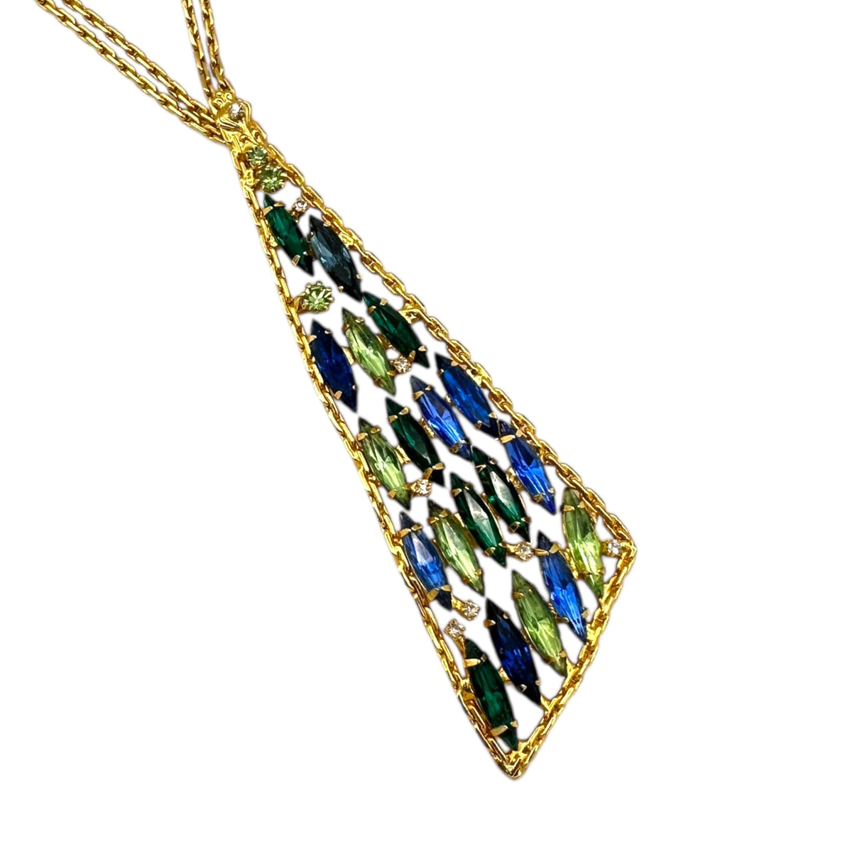 Close up of pendant of Vintage gold chain tie necklace with blue and green marquise rhinestone pendant on white background.