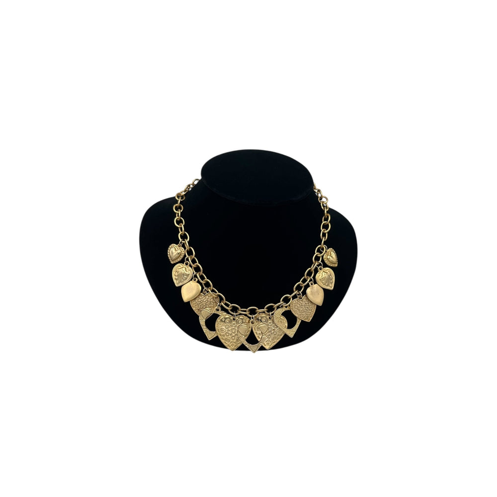 Vintage gold heart charm necklace with textured hearts and link chain displayed on black velvet bust.