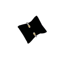 Vintage silver twisted cable open cuff bracelet with gold and rhinestone ends displayed on black pillow white background.