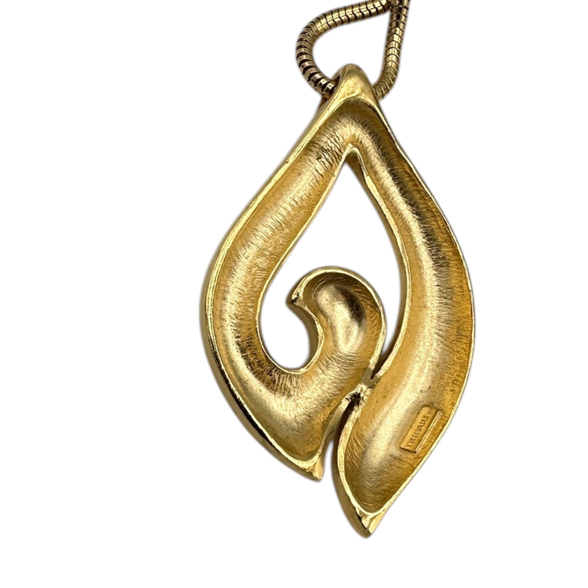 Back view of Vintage Trifari gold modernist pendant necklace on long snake chain on white background.