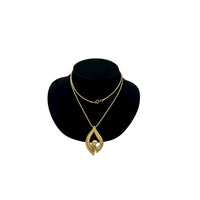 Vintage Trifari gold modernist pendant necklace on long snake chain on black bust.