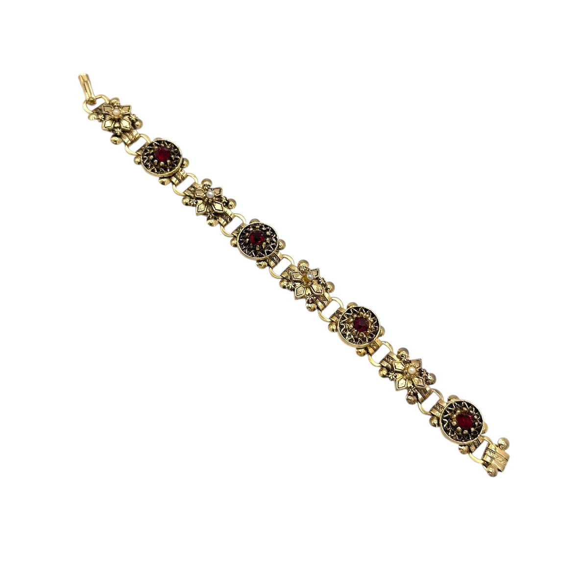 Close up view of Vintage Victorian Revival gold tone book chain bracelet with ruby red glass cabochon centerpiece displayed on white background.