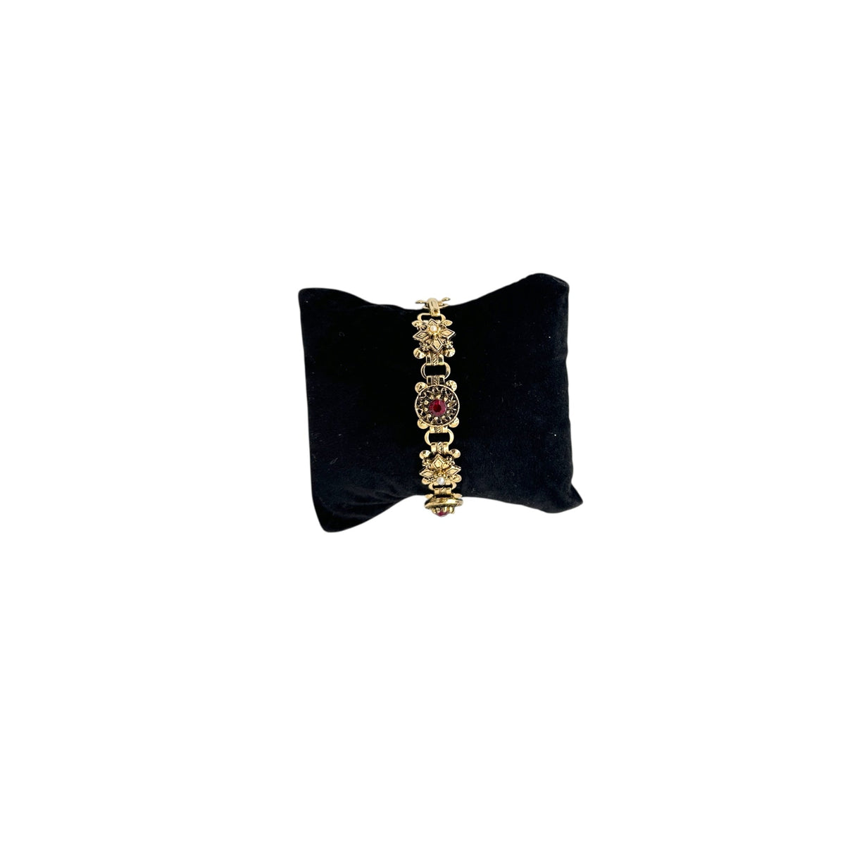 Front view of Vintage Victorian Revival gold tone book chain bracelet with ruby red glass cabochon centerpiece displayed on black velvet pillow.